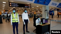 FILE - A health worker monitors a screen showing a thermal scan to check the temperatures of passengers at the Kotoka International Airport in Accra, Ghana Jan. 30, 2020.