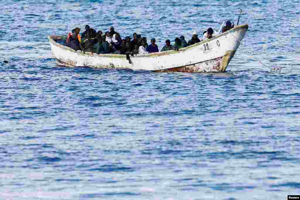 A Spanish Coast Guard vessel tows a fibreglass boat with migrants onboard to the port of Arguineguin, on the island of Gran Canaria, Spain, De. 25, 2024.