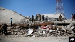 Policemen gather at the site of a Saudi-led airstrike on the police headquarters in Sana'a, Yemen, Jan. 18, 2016.
