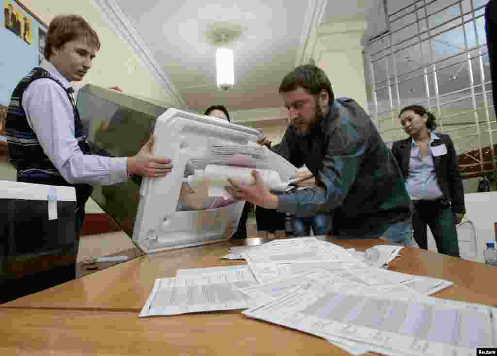 Poll workers empty a ballot box after voting finished in the mayoral election in Moscow, Sept. 8, 2013.