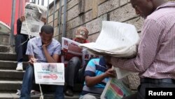 የብሔራዊ ምርጫ አዲስ አበባ ውስጥ በሚካሄድበት ግዜ ኢትዮጵያውያን ጋዜጣ እያነበቡ እአአ 2015 ዓ.ም. [ፎቶ ፋይል - ሮይተርስ] 