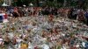 FILE - People gather at the makeshift memorial July 18, 2016, after a minute of silence on the famed Promenade des Anglais in Nice, southern France, to honor the victims of an attack near the area where a truck mowed through revelers.