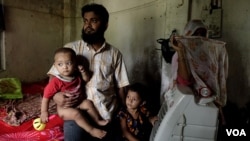 Mohammad Salim, seorang pengungsi Rohingya, bersama istri dan anaknya, di desa di timur negara bagian Bengal Barat. Salim baru saja ditangkap polisi India dan ditahan dengan tuduhan imigran ilegal. (Shaikh Azizur Rahman/VOA)