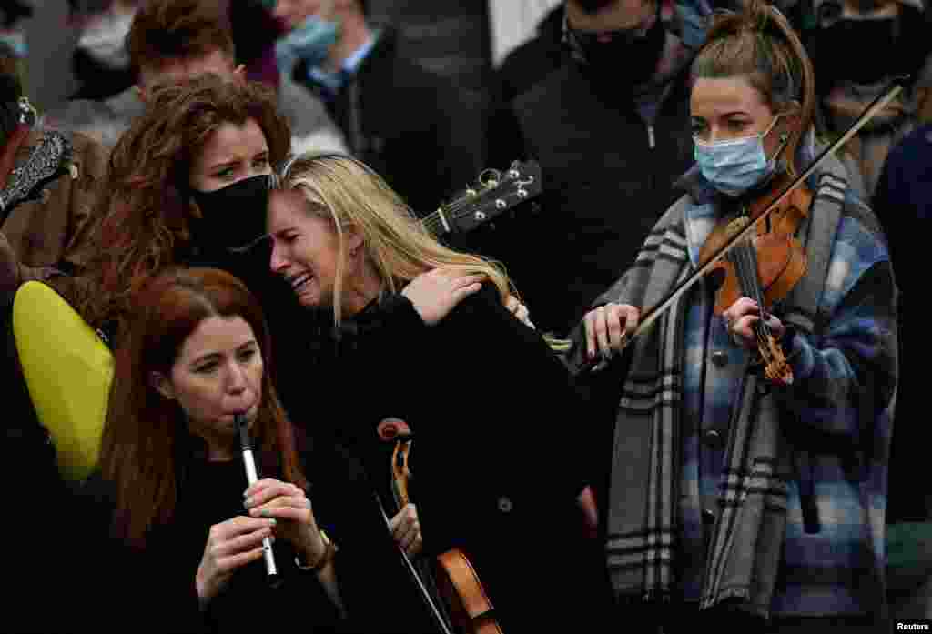 A musician reacts during the funeral of late 23-year-old teacher, Ashling Murphy, who was murdered while out jogging, outside the St. Brigid's Church in Mountbolus near Tullamore, Ireland.