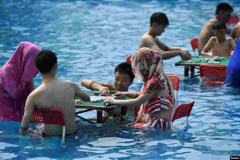 在中国重庆,炎热的一天,人们在水上公园玩麻将。(2017年8月2日)
