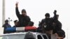 An Iraqi riot police officer flashes the V-sign as his unit returns to its headquarters from clashes between Iraqi army and al-Qaida fighters Basra, Iraq's second-largest city, Jan. 5, 2014.