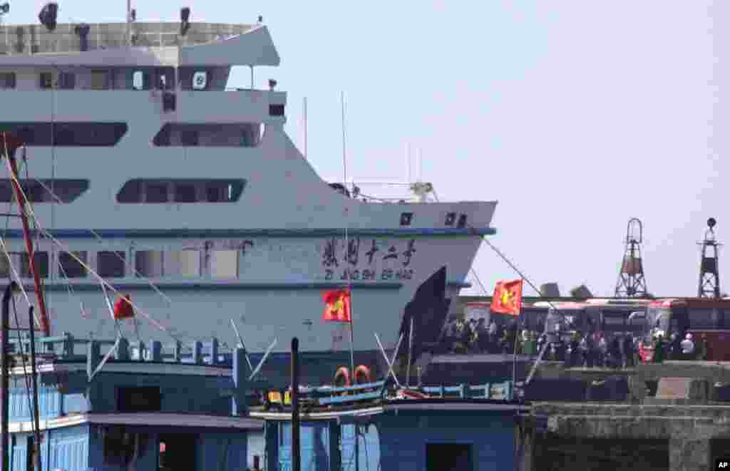 While riot police stand by, workers board a Chinese ship at Vung Ang port, Ha Tinh province, Vietnam, May 19, 2014. 