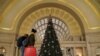 Holiday week train passengers walk by a Christmas tree at Union Station, during the coronavirus disease (COVID-19) pandemic, in Washington, U.S., December 23, 2020