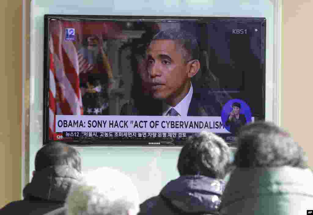 Warga menonton siaran berita televisi yang memperlihatkan Presiden AS Barack Obama di stasiun kereta api Seoul, Korea Selatan (22/12). (AP/Ahn Young-joon)