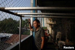 Jirat Buapromart stands on his roof terrace that has steel caging to keep long-tailed macaques away in Lopburi, Thailand, Feb. 3, 2024.