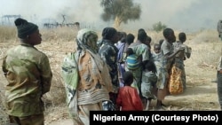 FILE - Nigerian soldiers rescue some people after chasing Boko Haram fighters out of a village in the Sambisa forest in Borno state, in 2016.