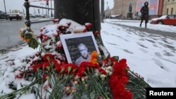 A portrait of Russian military blogger Vladlen Tatarsky, (real name Maxim Fomin), who was killed in the cafe explosion the day before, is placed among flowers near the blast site in Saint Petersburg, Russia April 3, 2023. 