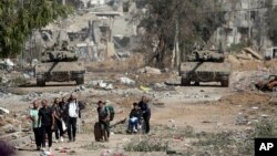 Warga Palestina melarikan diri ke Gaza utara ketika tank Israel memblokir jalan Salah al-Din di Jalur Gaza tengah pada 24 November 2023. (Foto: AP)
