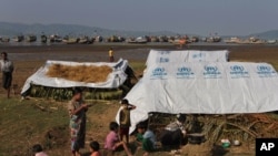 ရခိုင်ပြည်နယ်၊ ပေါက်တောမြို့နယ်က ဒုကသည်စခန်းတခုမှာ ကမန်မိခင် ချက်ပြုတ်ပြင်ဆင်နေစဉ် ကစားနေတဲ့ ကလေးများ။ (ယခင်မှတ်တမ်းဓာတ်ပုံ)