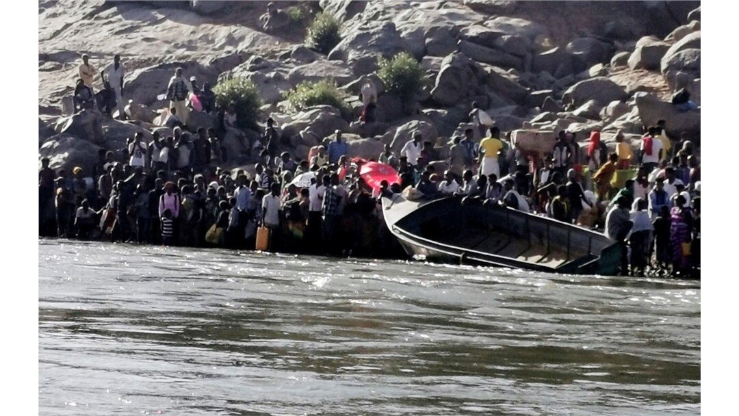 Ethiopians who fled the ongoing fighting in Tigray region prepare to cross the Setit River on the Sudan-Ethiopia border in Hamdayat village in eastern Kassala state, Sudan, Nov. 14, 2020.