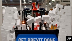 Premijer Velike Britanije Boris Džonson vozi bager sa natpisom "Obavimo Bregzit" kroz simboličan zid tokom svoje predizborne kampanje.