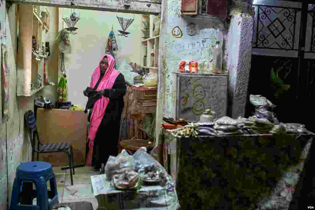 Manal Ahmed, who came from Omdurman because of the lack of the medical care in Sudan, says "I came here to get my son treatment in better hospitals, then I started this shop to sell herbs to help my family with living expenses." In Cairo. (H. Elrasam/VOA)