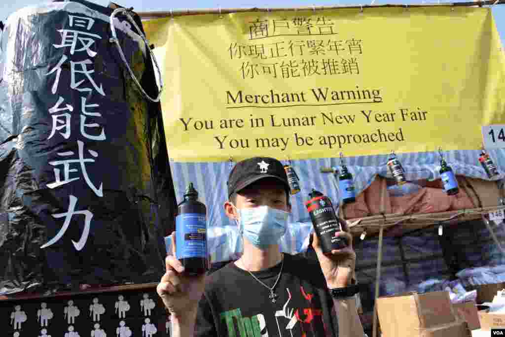 維園年宵市場檔主吳先生展示模仿警方胡椒噴霧的水瓶(左),以及模仿催淚彈發射器的打火機