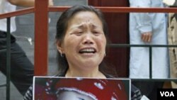Zheng Shuzhen, seorang nenek di Tiongkok memegang foto cucunya yang meninggal setelah minum susu yang tercemar.