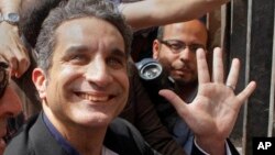 Bassem Youssef, Egyptian TV satirist, waves to supporters in Cairo before talks with authorities about charges he insulted Islam and the nation's president, March 31, 2013.