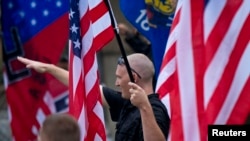 FILE - A member of a white supremacy group gives a fascist salute during a gathering in West Allis, Wisconsin, Sept. 3, 2011.