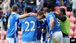 Tim sepak bola Wigan merayakan kemenangan atas Newcastle, Sabtu (28/4).