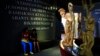 Rwandan people sit inside the Kigali Genocide Memorial Museum as the country prepares to commemorate the 20th anniversary of the 1994 genocide in the capital Kigali, April 5, 2014.