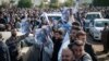 People hold photos of a child killed in the Iranian strikes at the house of Peshraw Dizayi during a protest in front of the U.N. office in Irbil, Iraq, Jan. 16, 2024. Dizayi, a prominent Kurdish businessman, was killed in one of the Irbil strikes along with members of his family.
