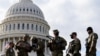 National Guard troops receive guns and ammunition outside the U.S. Capitol 