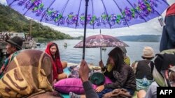Warga berkumpul di pinggir Danau Toba (20/6) menunggu kabar anggota keluarga sementara tim penyelamat mencari korban penumpang Kapal Motor Sinar Bangun yang tenggelam di Danau Toba.