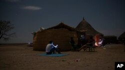 Para pengungsi Tigray yang melarikan diri dari konflik di wilayah Tigray, Etiopia, sedang mencari sinyal ponsel di Hamdayet, bagian timur Sudan, near the border perbatasan Etiopia, 23 Maret 2021. (Foto: AP Photo/Nariman El-Mofty)