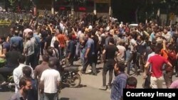 In this picture taken by a citizen journalist, Iranian security forces dressed in black confront anti-government protesters in Iran’s third-largest city, Isfahan, during demonstrations that began July 31, 2018, and continued Aug. 1, 2018.