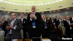 Algeria's Prime Minister Abdelmalek Sellal (C) applauds after lawmakers voted for the constitutional reforms in Algiers, Algeria, Feb. 7, 2016.