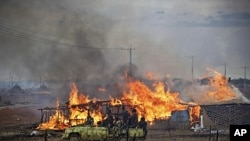 2011苏苏丹武装部队卡车经过苏丹中部地区一个燃烧的居民区(资料照片)