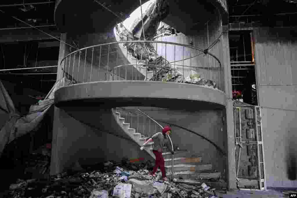 A child walks through debris towards a spiral staircase at the Gaza Municipality's Rashad al-Shawa Cultural Centre, which was heavily-damaged by Israeli bombardment.