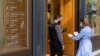 A woman is checked for her Covid-19 vaccination certificate in order to be allowed to enter a shop in Athens, Greece, Nov. 6, 2021. 