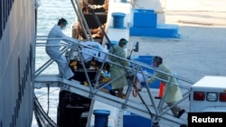  Para petugas penyelamat memindahkan seorang pasien dari kapal pesiar Zaandam milik Hollan American Line, yang terjangkit virus corona di Port Everglades, Fort Lauderdale, Florida, 2 April 2020. (Foto: REUTERS)