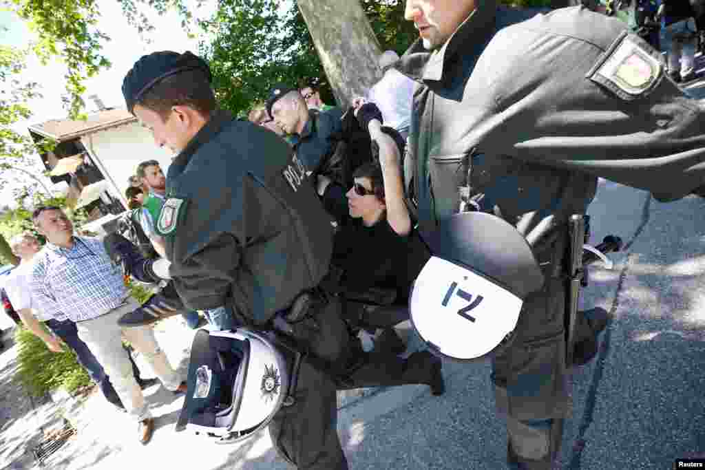 德国防暴警察在德国南部加尔米施-帕腾基兴县抬走一名反对七国集团的静坐抗议者。（2015年6月7日）