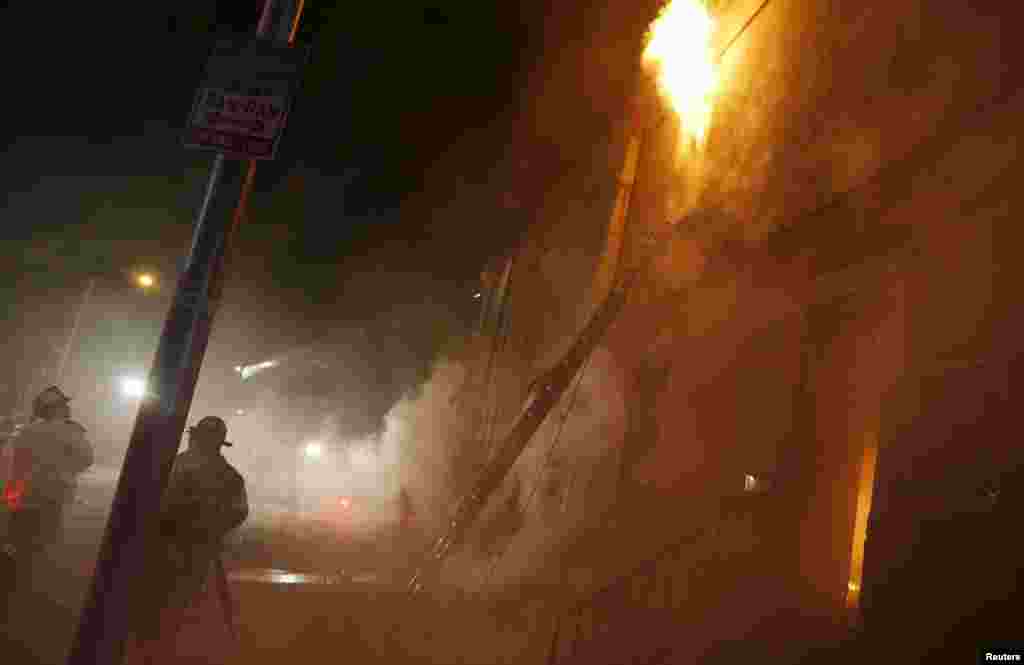 Firefighters battling a blaze on East Biddle street at Montford Avenue, Baltimore, April 28, 2015.
