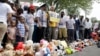 Family, friends and supporters pause for a moment of silence at a memorial to Michael Brown, Sunday, Aug. 9, 2015, in Ferguson, Missouri.