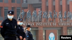 当世卫组织新冠病毒源头调查组视察武汉的中国科学院病毒研究所期间，中国保安人员在研究所外站岗。 （2021年2月3日）