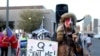 FILE - In this Nov. 5, 2020, photo, Jacob Anthony Chansley, who also goes by the name Jake Angeli, a Qanon believer, speaks to a crowd of President Donald Trump supporters in Arizona.