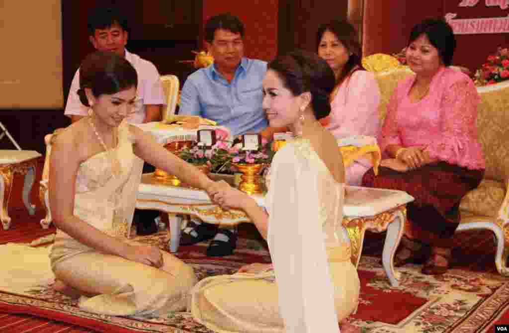 Orangtua kedua belah pihak menyaksikan pasangan Arisa Thanommek dan Pacharee Hungsabut bertukar cincin dalam upacara pernikahan di Bangkok (19/5). (VOA/Daniel Schearf)