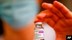 Seorang anggota staf medis memegang botol vaksin AstraZeneca-Oxford COVID-19, 8 Februari 2021. (Foto: AP)