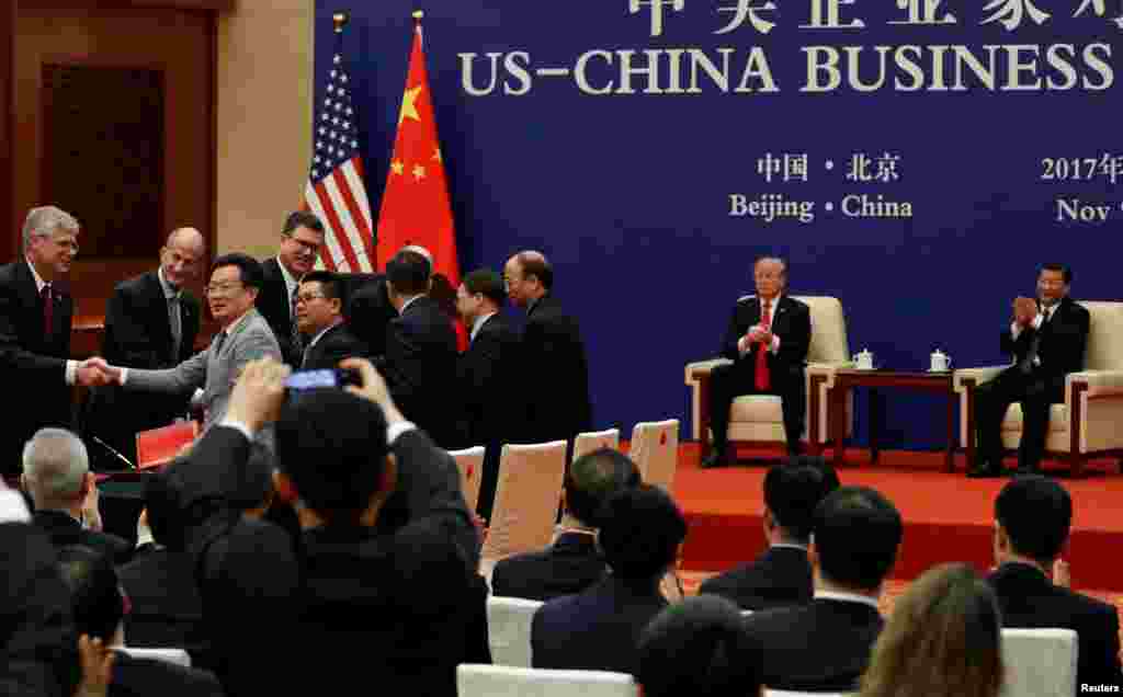 在北京人民大会堂举行的签约仪式上,美中企业家握手,美国总统川普和中国国家主席习近平参加(2017年11月9日)。川普总统11月13日在马尼拉说:“我们和贸易伙伴取得了一些重大进展,其幅度超出你的想象。商业公司还做了3000亿美元的生意,包括中国的2500亿美元购买,还会有更多。贸易有很大进展。我们与几乎所有国家都有贸易赤字。这些赤字将很快、很大幅度的缩减。”