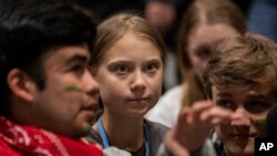 Aktivis perubahan iklim, Greta Thunberg (tengah), berbincang dengan sesama aktivis muda di konferensi iklim, COP25, di Madrid, 6 December 2019.