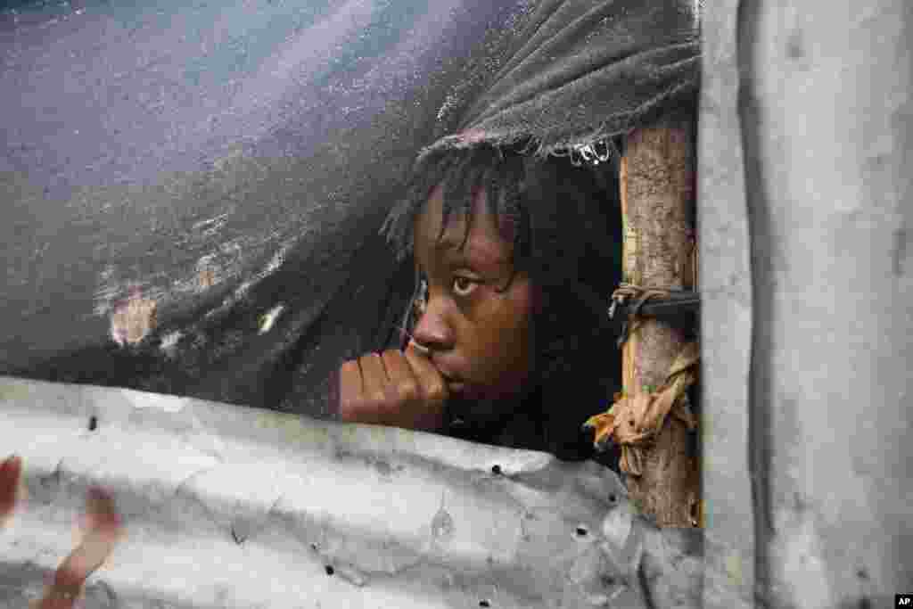 A girl watches as authorities arrive to evacuate people from her house in Tabarre, Haiti, Oct. 3, 2016.