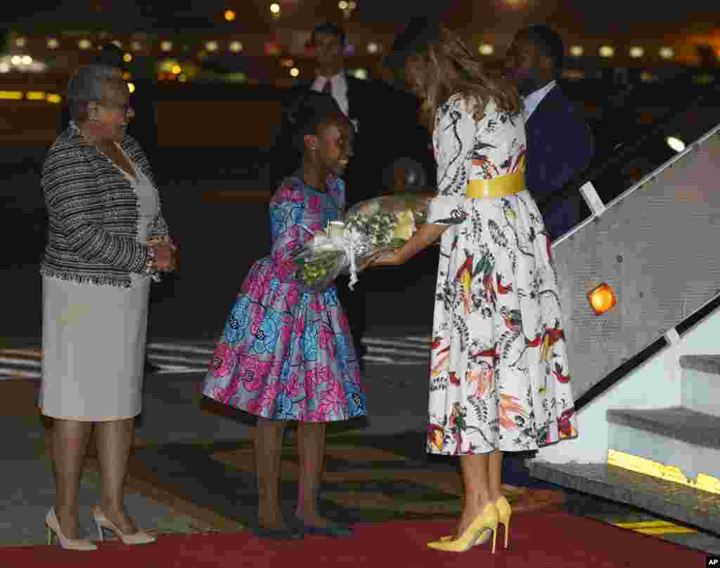 First lady Melania Trump is greeted by a flower girl and Margaret Kenyatta, Kenya's first lady as she arrives at Jomo Kenyatta International Airport in Nairobi, Kenya, Oct. 4, 2018.