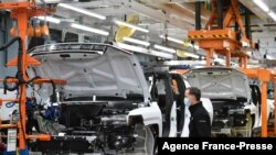 FILE - GMC Hummer EVs are seen on an assembly line at he General Motors Factory ZERO electric vehicle assembly plant in Detroit, Michigan, Nov. 17, 2021.