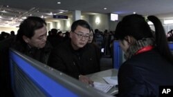 지난달 22일 북한 평양 공항의 '고려링크' 부스에서 휴대전화를 대여하는 외국인들.
